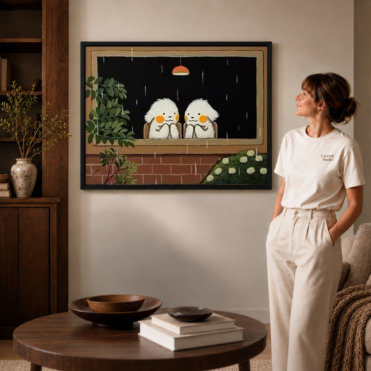 Rainy window birds canvas art displayed in a black frame beside a woman, with soft room lighting.
