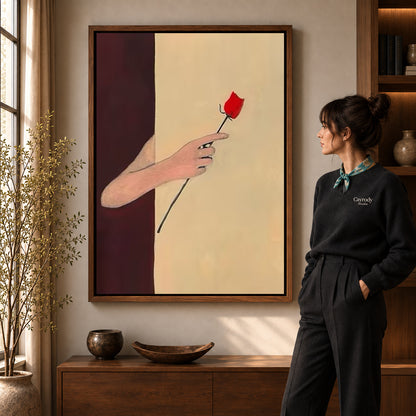 Red rose canvas art in a walnut frame beside a woman in a warmly lit living room.