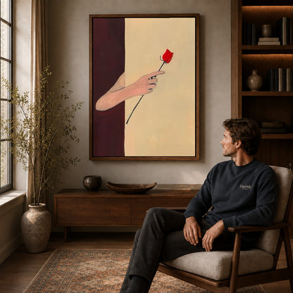 Red rose canvas art above a wooden console near a seated man and leafy branches.
