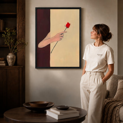 Red rose canvas art displayed in a black frame beside a woman, with soft room lighting.
