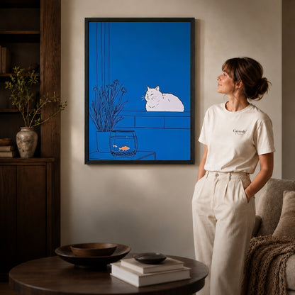 Blue cat canvas art displayed in a black frame beside a woman, with soft room lighting.