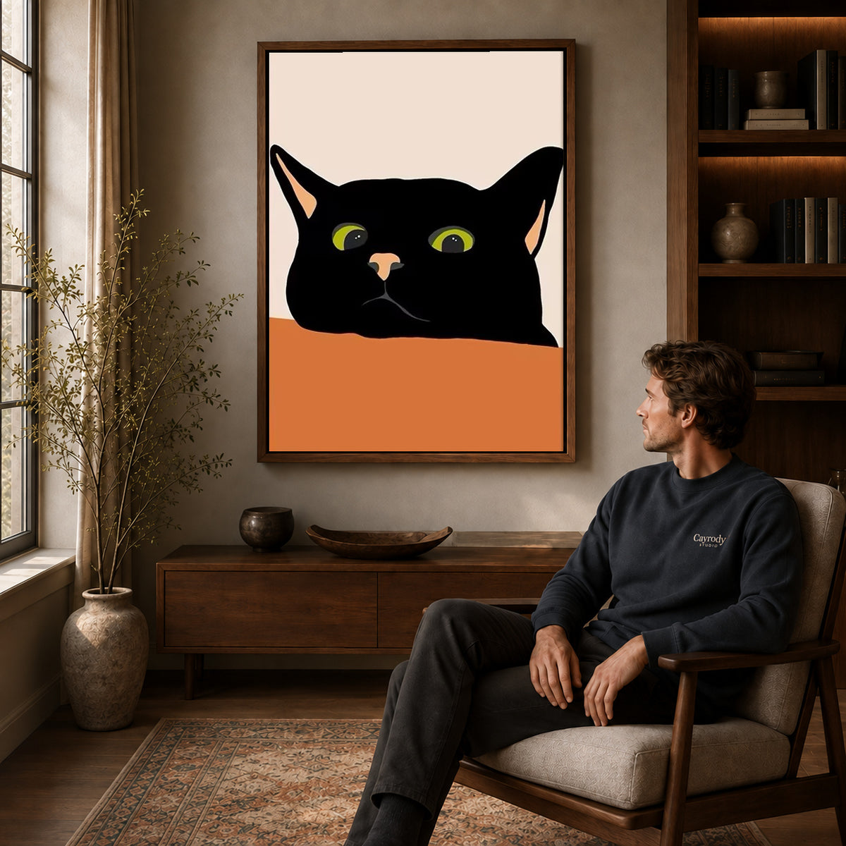 Black cat canvas art above a wooden console near a seated man and leafy branches.