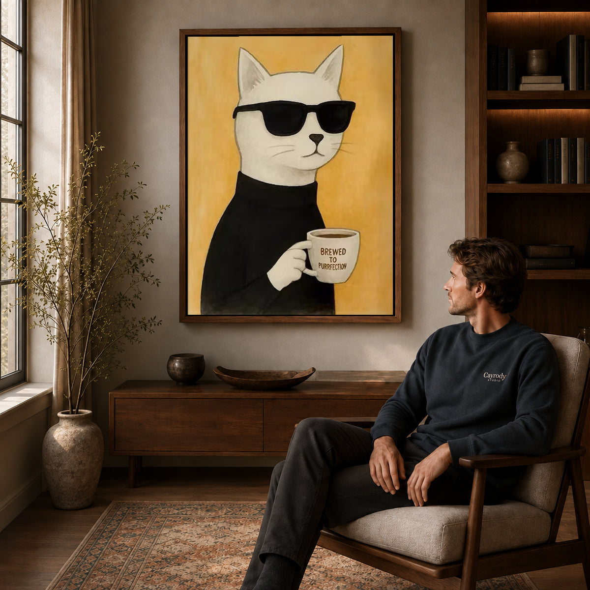 Coffee cat canvas art above a wooden console near a seated man and leafy branches.