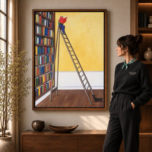 Library reader canvas art in a walnut frame beside a woman in a warmly lit living room.