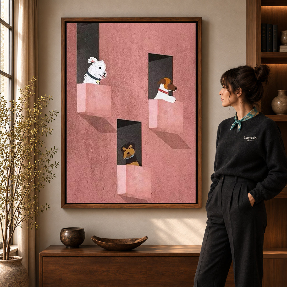 Window dogs canvas art in a walnut frame beside a woman in a warmly lit living room.