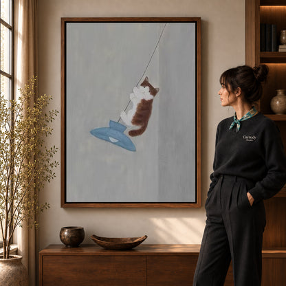 Pendant cat canvas art in a walnut frame beside a woman in a warmly lit living room.