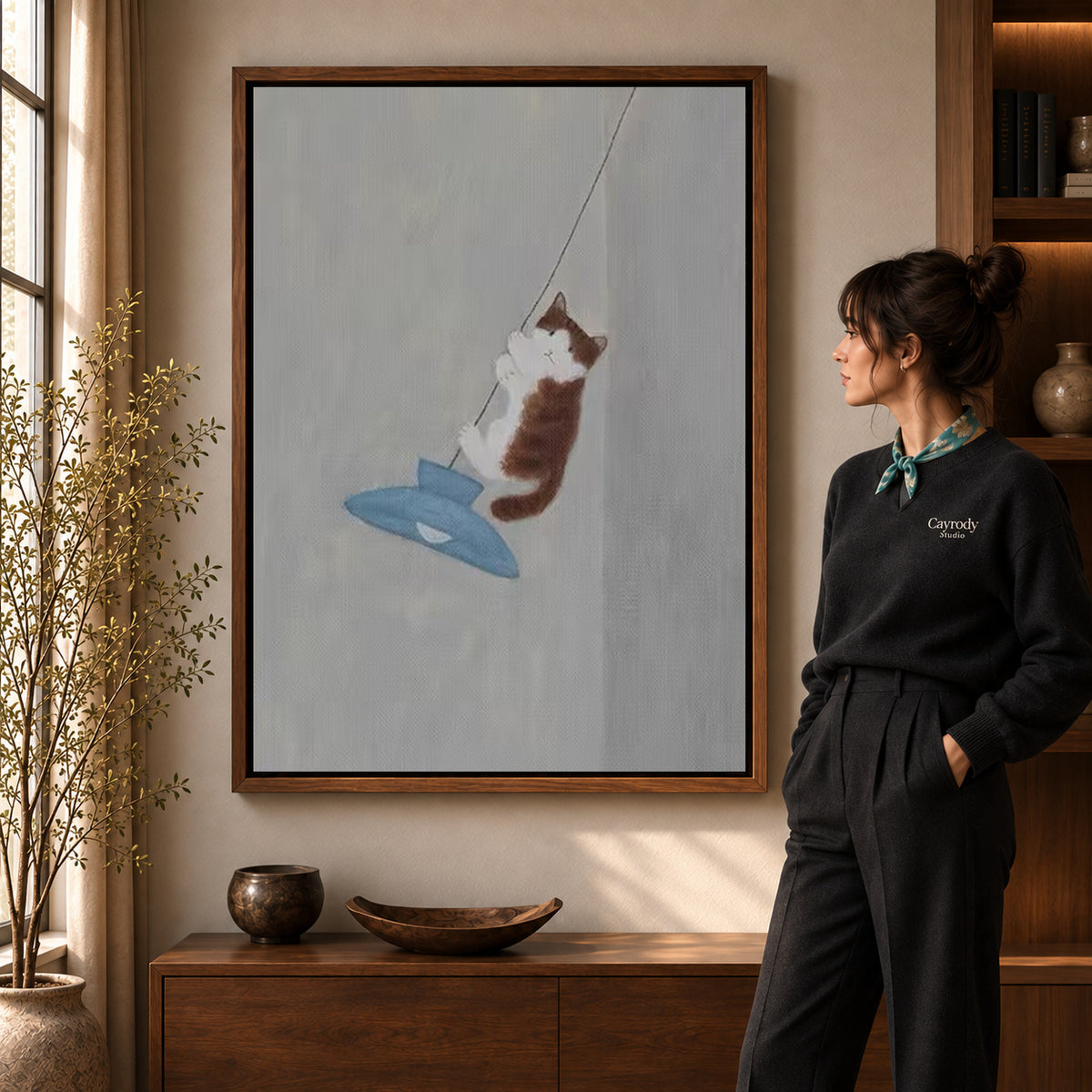Pendant cat canvas art displayed in a walnut frame against a warm wall near a wooden console.