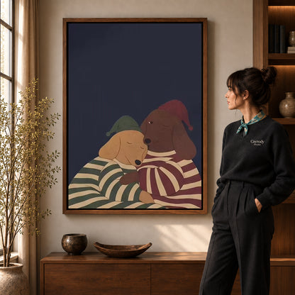 Pajama Dachshunds canvas art in a walnut frame beside a standing woman and wooden console.
