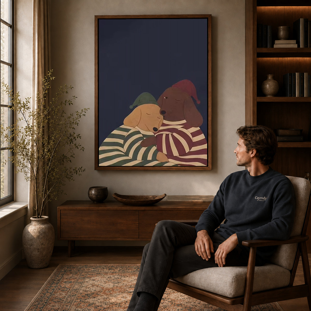 Pajama Dachshunds canvas art above a wooden console beside a seated man in a warm room.