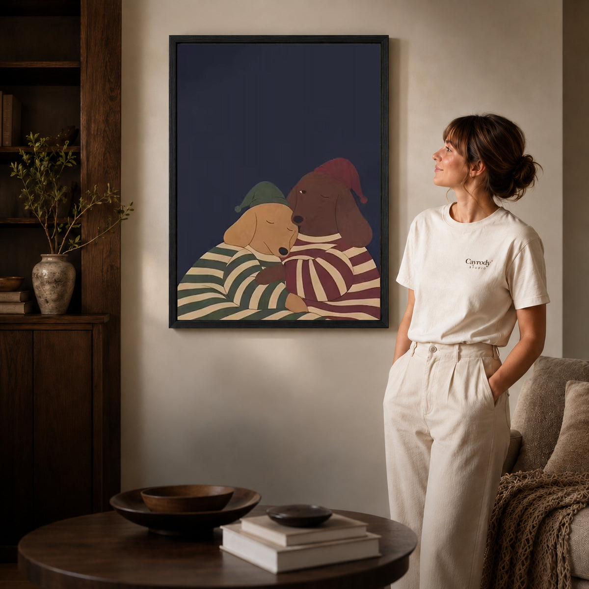 Pajama Dachshunds canvas art in a black frame above books in a welcoming living room.