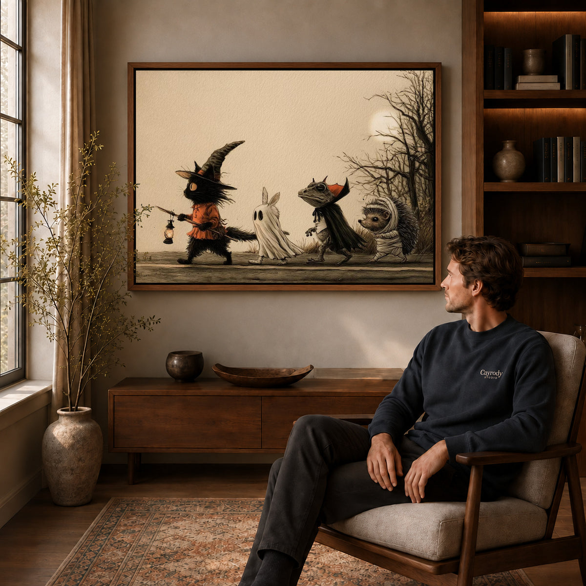 Halloween Parade canvas art above a wooden console beside a seated man in a warm room.