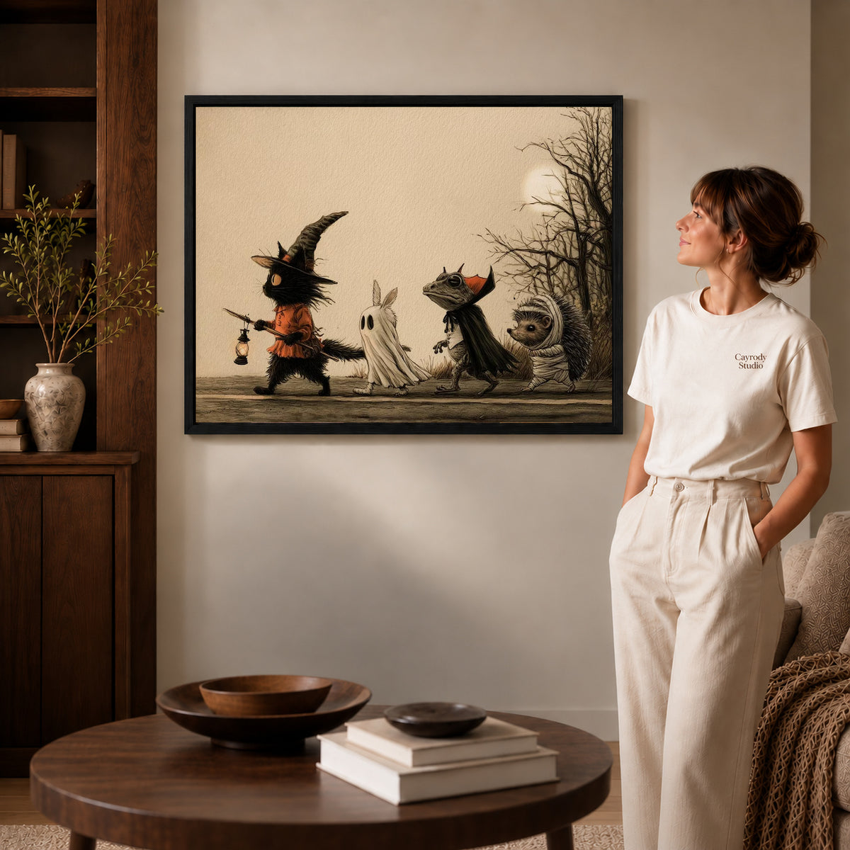 Halloween Parade canvas art in a black frame above books in a welcoming living room.