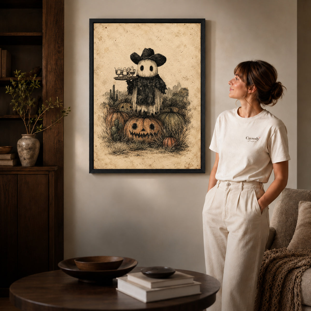 Black framed ghost cowboy canvas art displayed beside a woman in a warm living room.