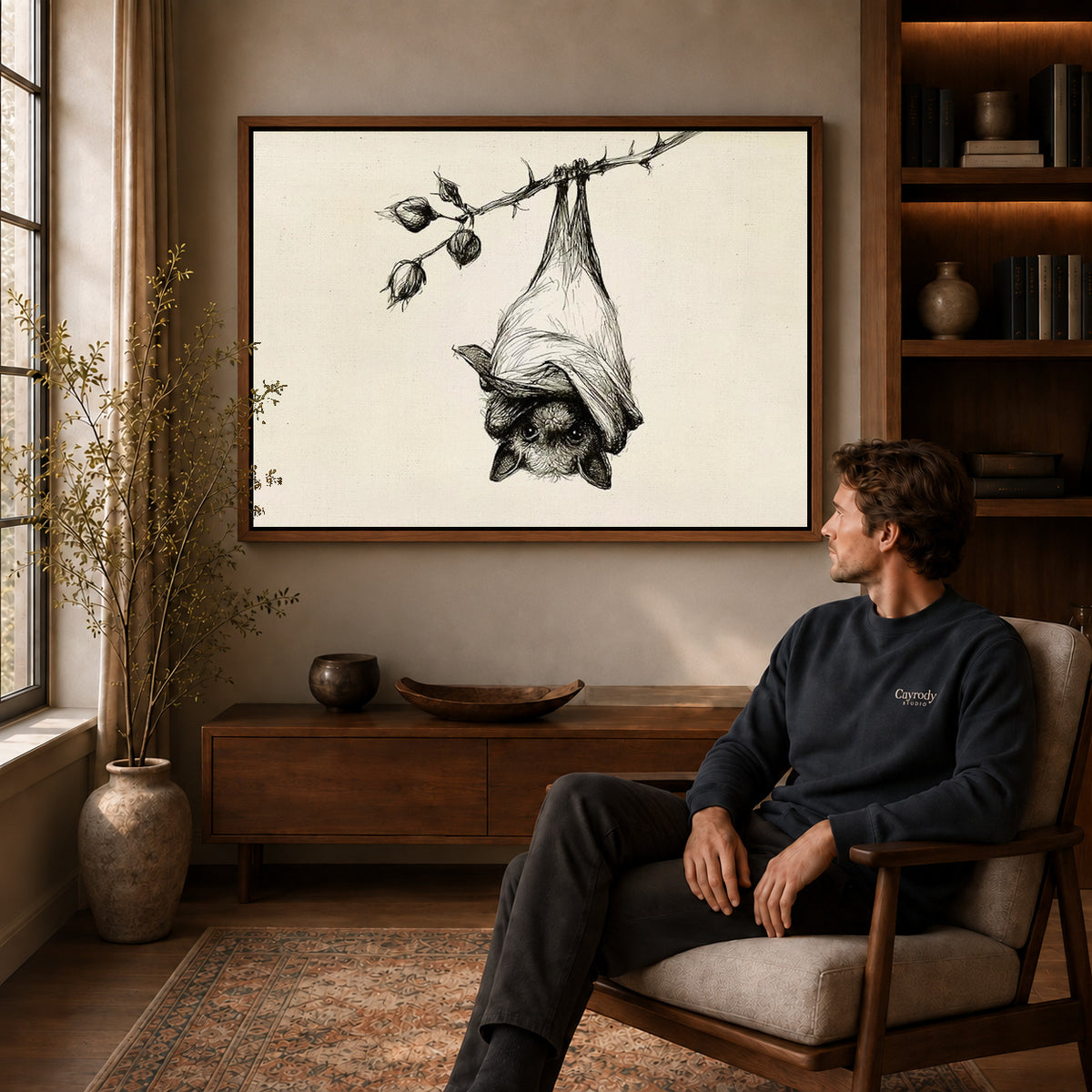 Hanging Bat canvas art above a wooden console beside a seated man in a warm room.