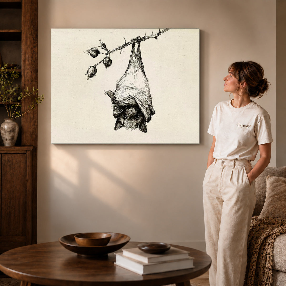 Hanging Bat canvas art displayed as gallery wrapped canvas beside a woman in natural light.