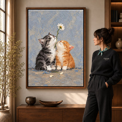 Daisy Kittens canvas art in a walnut frame beside a standing woman and wooden console.