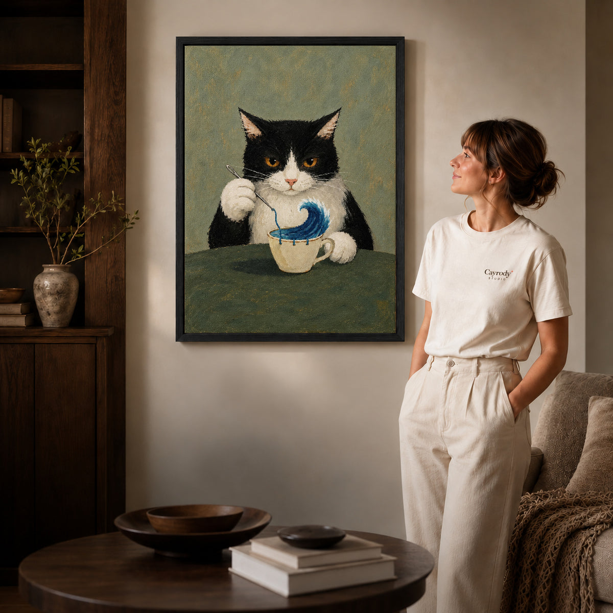 Ocean Teacup canvas art in a black frame above books in a welcoming living room.