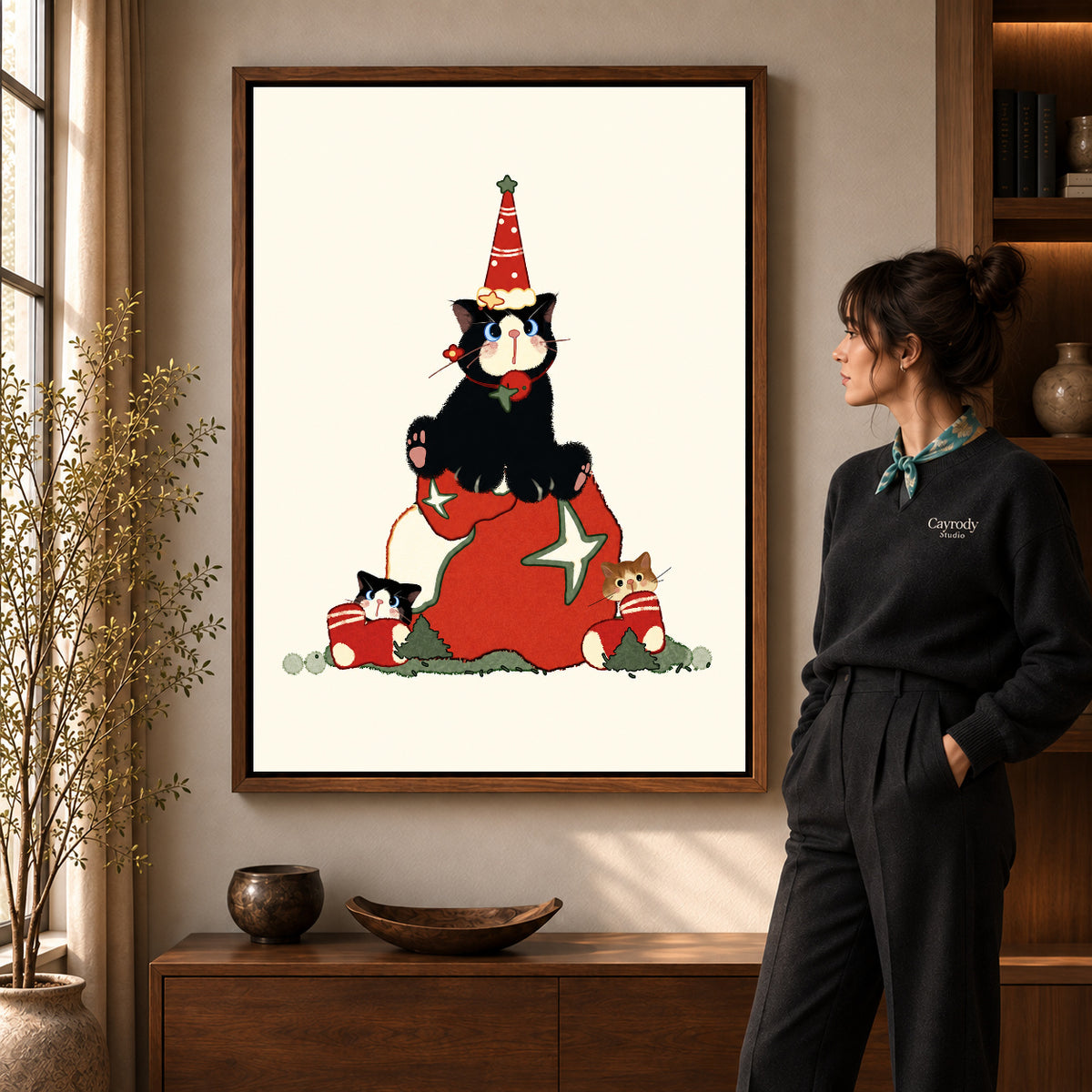Walnut framed christmas kittens canvas art shown beside a standing woman and a wooden console.