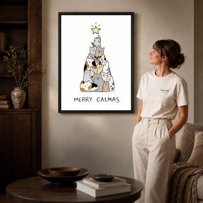 Cat Christmas canvas art in a black frame above books in a welcoming living room.