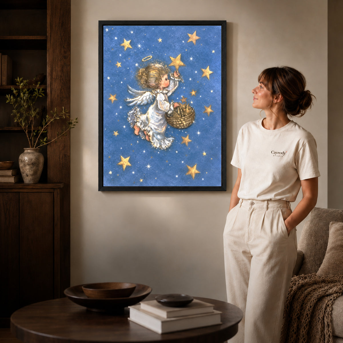 Starlight Angel canvas art in a black frame above books in a welcoming living room.