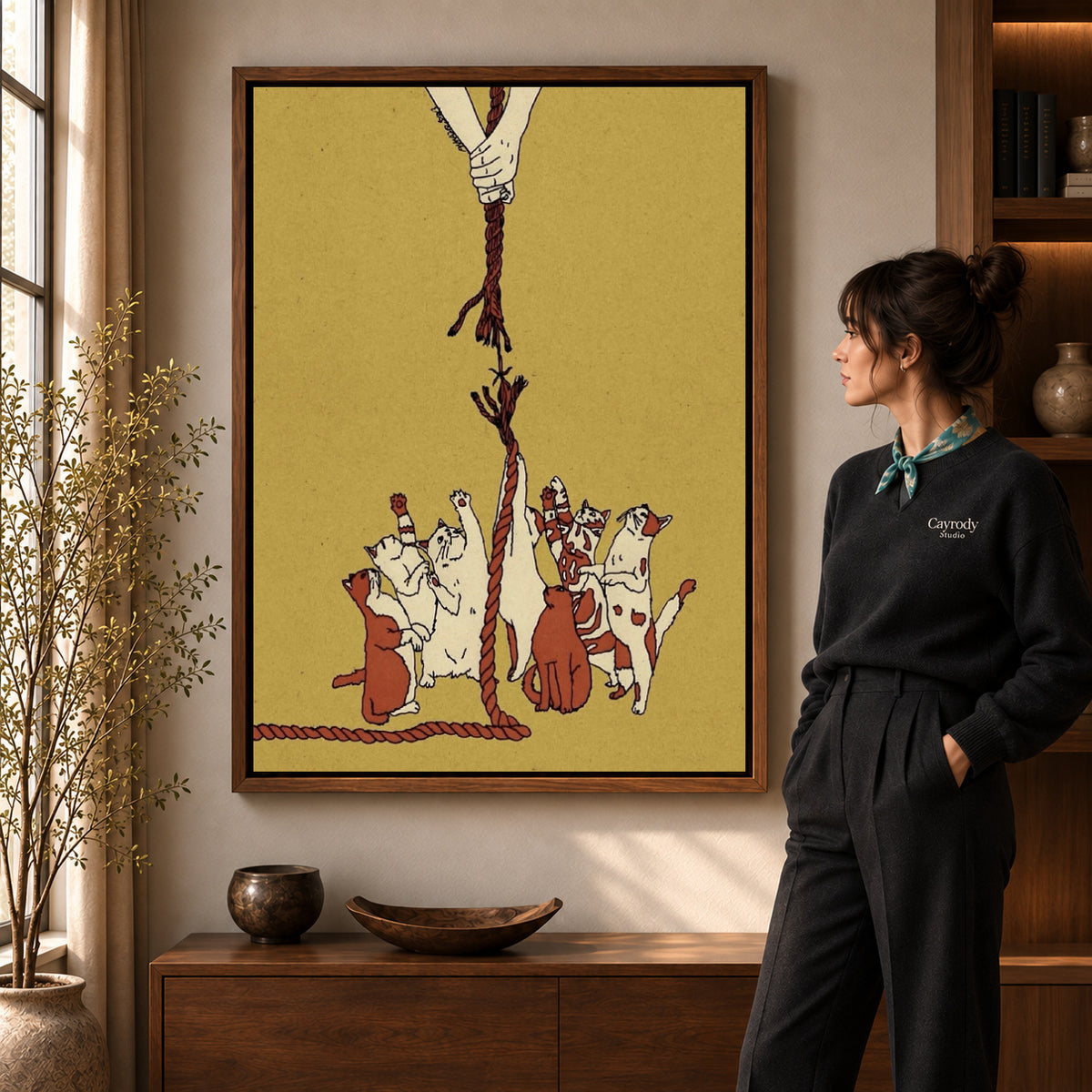 Playful Dogs canvas art in a walnut frame beside a standing woman and wooden console.