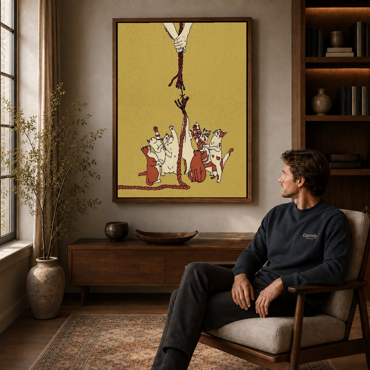 Playful Dogs canvas art above a wooden console beside a seated man in a warm room.