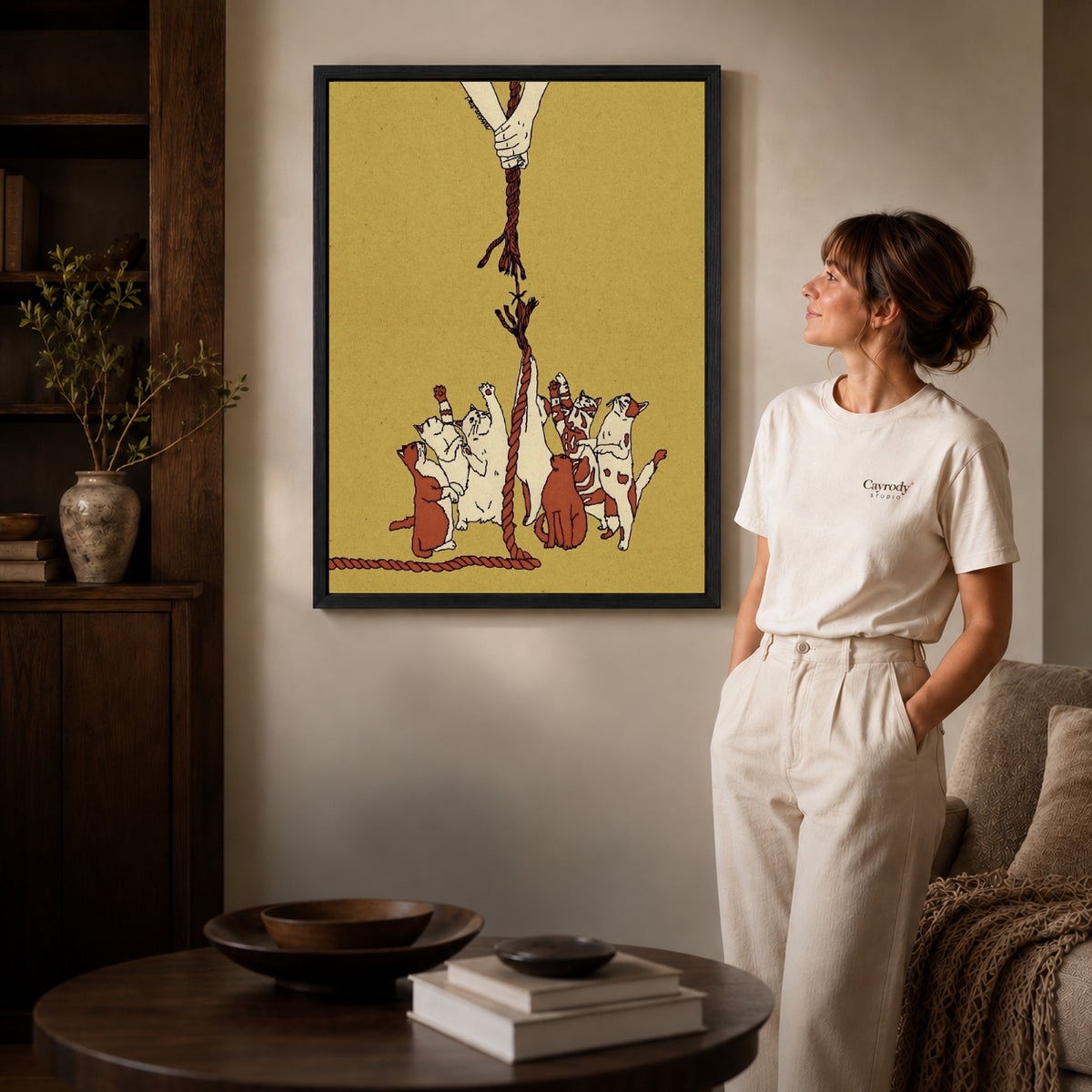Playful Dogs canvas art in a black frame above books in a welcoming living room.
