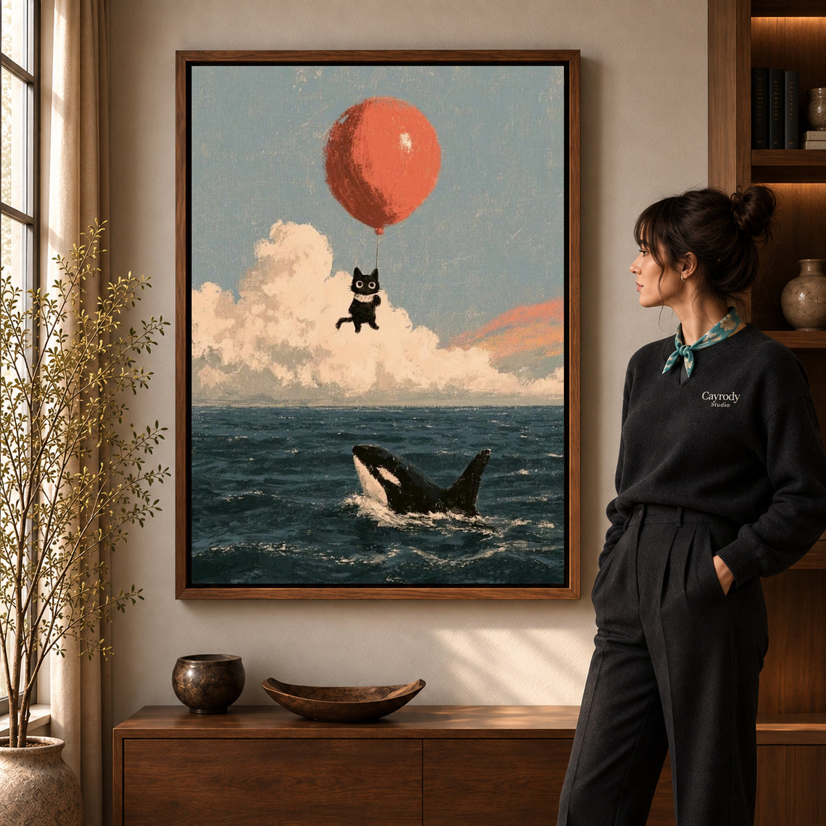 Walnut framed balloon cat canvas art shown beside a standing woman and a wooden console.