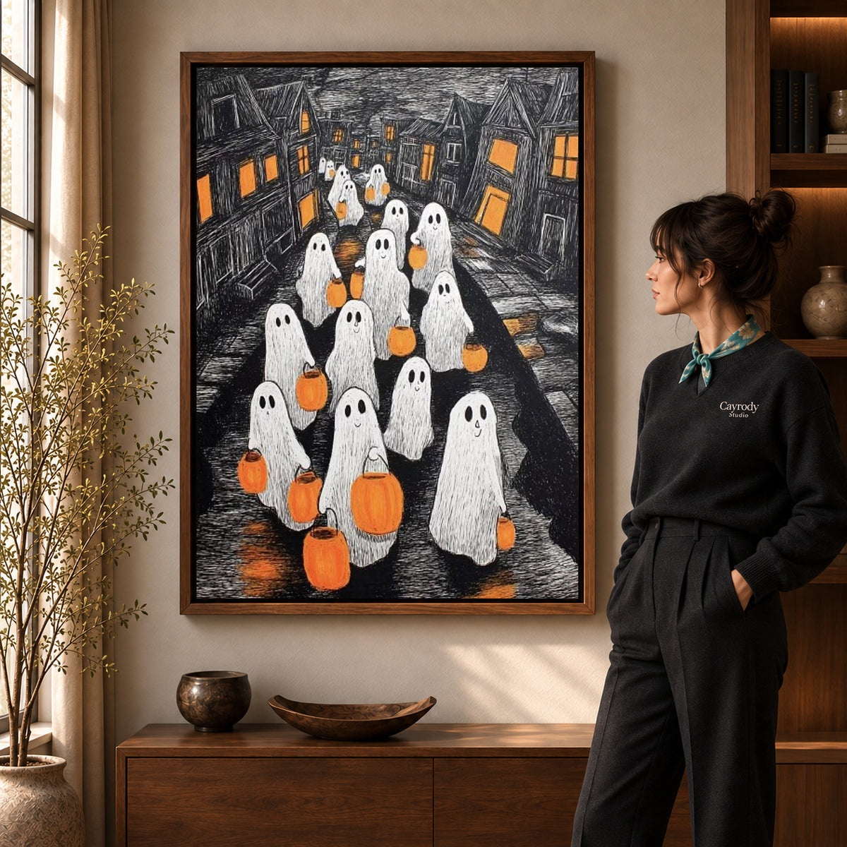 Walnut framed pumpkin ghosts canvas art shown beside a standing woman and a wooden console.