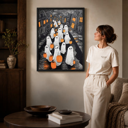 Black framed pumpkin ghosts canvas art displayed beside a woman in a warm living room.
