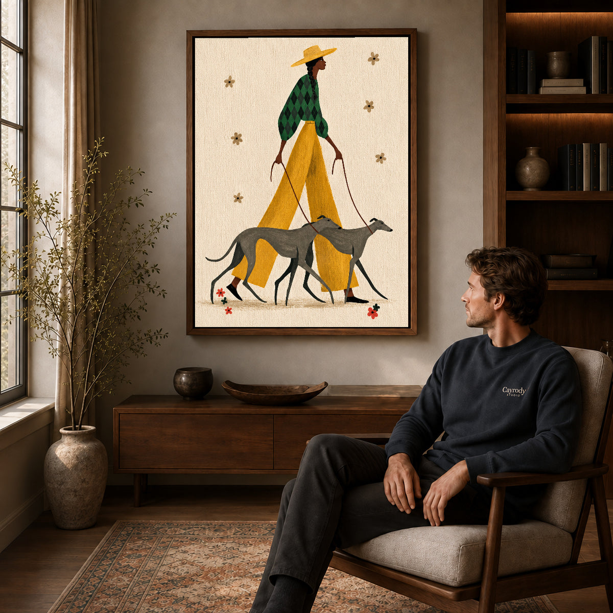 Stylish Greyhound Walk canvas art above a wooden console beside a seated man in a warm room.