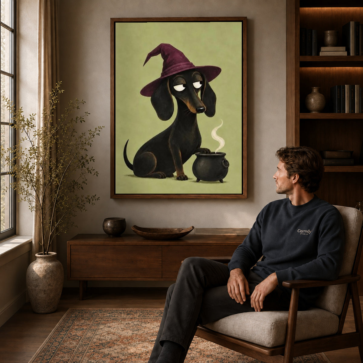 Dachshund Witch canvas art above a wooden console beside a seated man in a warm room.