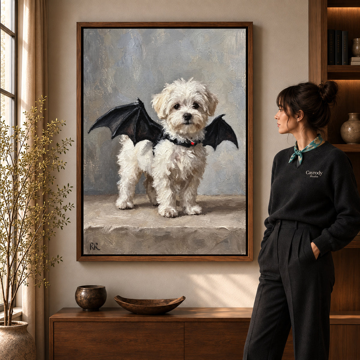 Bat Wing Puppy canvas art in a walnut frame beside a standing woman and wooden console.
