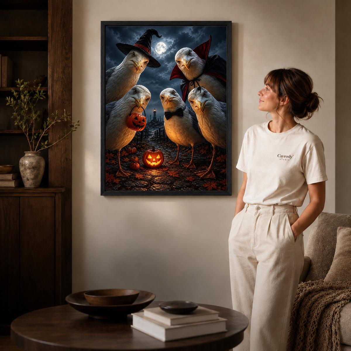Spooky Seagull Crew canvas art in a black frame above books in a welcoming living room.