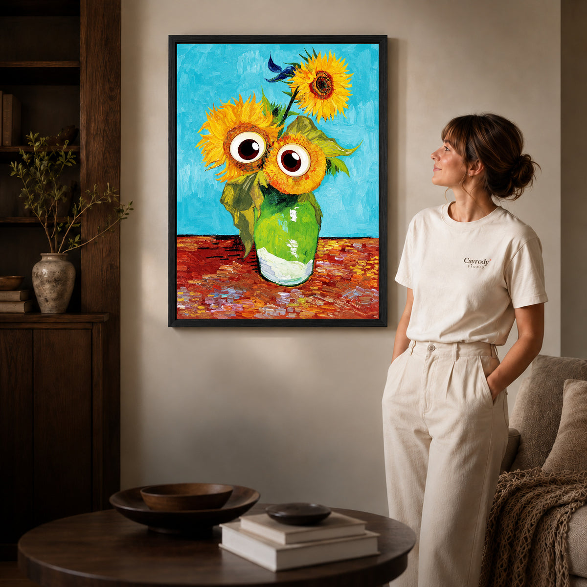 Googly Sunflowers canvas art in a black frame above books in a welcoming living room.