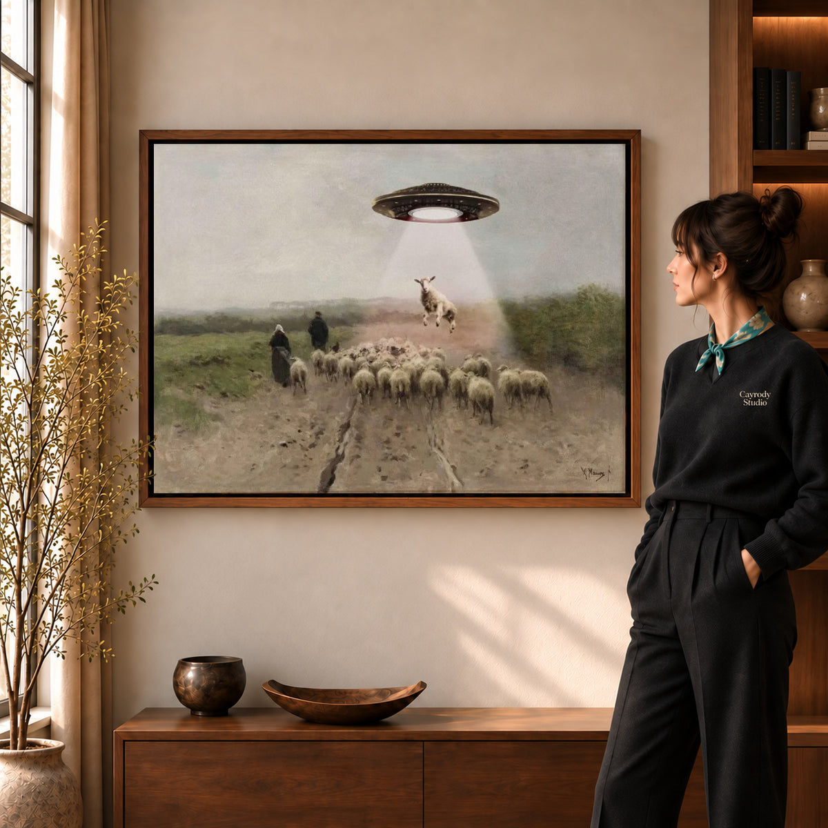 Walnut framed alien sheep visit canvas art shown beside a standing woman and a wooden console.