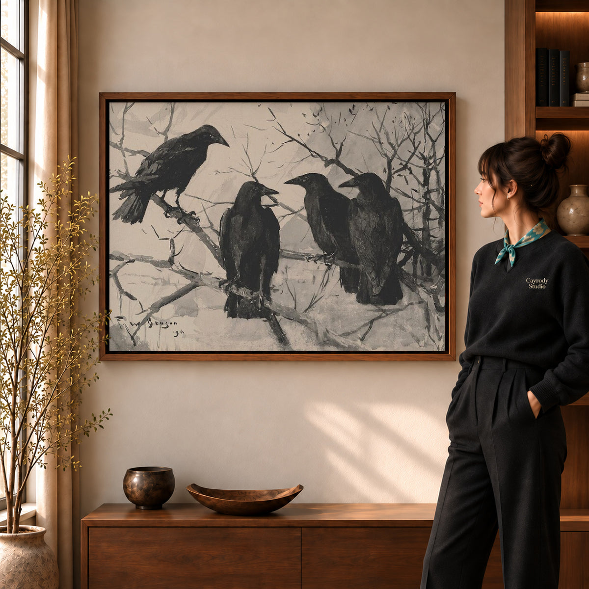 Four Ravens canvas art in a walnut frame beside a standing woman and wooden console.