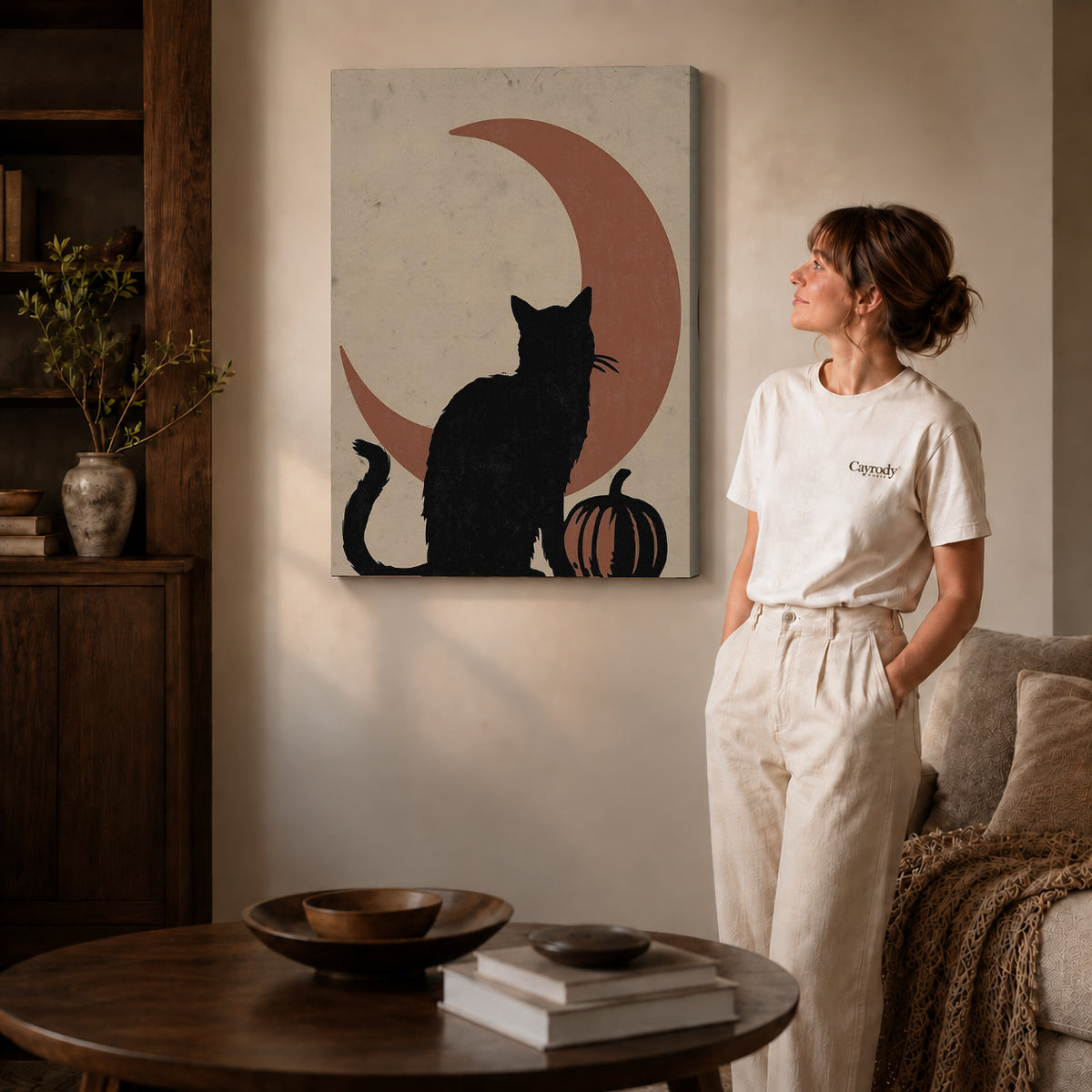Gallery wrapped black cat moon canvas art with visible canvas edges beside a standing woman.