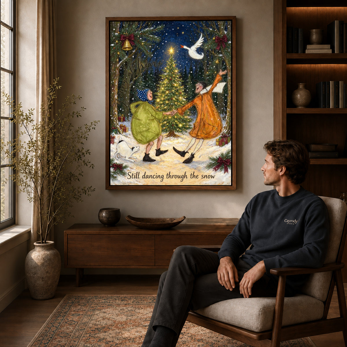 Snow Dance Couple canvas art above a wooden console beside a seated man in a warm room.