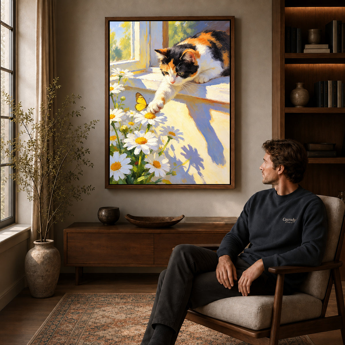 Butterfly Window Cat canvas art above a wooden console beside a seated man in a warm room.