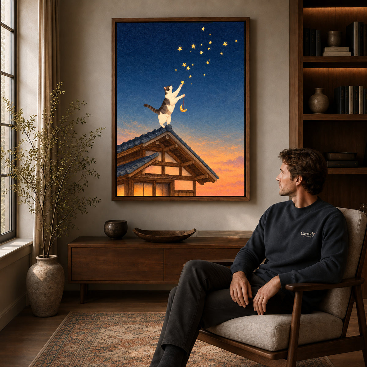 Stargazing Rooftop Cat canvas art above a wooden console beside a seated man in a warm room.
