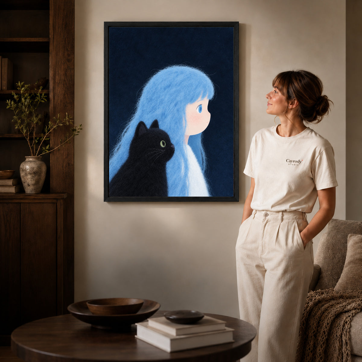 Black framed blue haired companion canvas art displayed beside a woman in a warm living room.