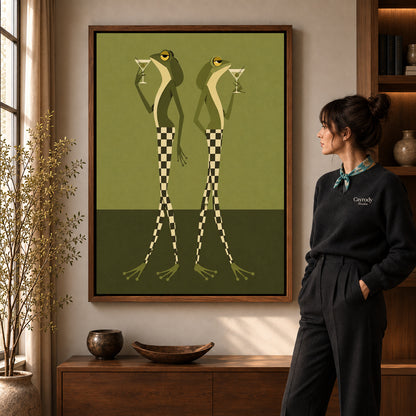 Martini Frogs canvas art in a walnut frame beside a standing woman and wooden console.
