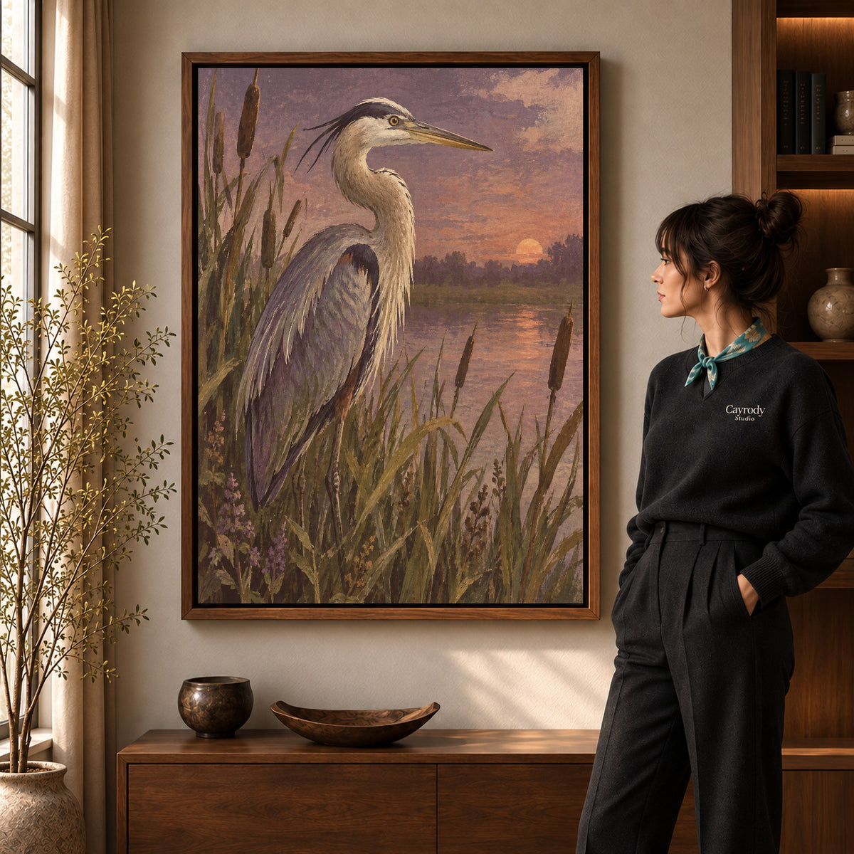 Walnut framed marsh heron canvas art shown beside a standing woman and a wooden console.