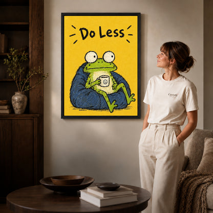 Black framed resting frog canvas art displayed beside a woman in a warm living room.