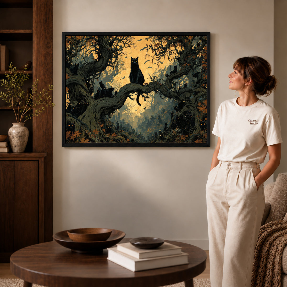 Enchanted Cat Forest canvas art in a black frame above books in a welcoming living room.