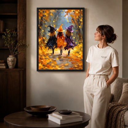 Black framed autumn witch friends canvas art displayed beside a woman in a warm living room.