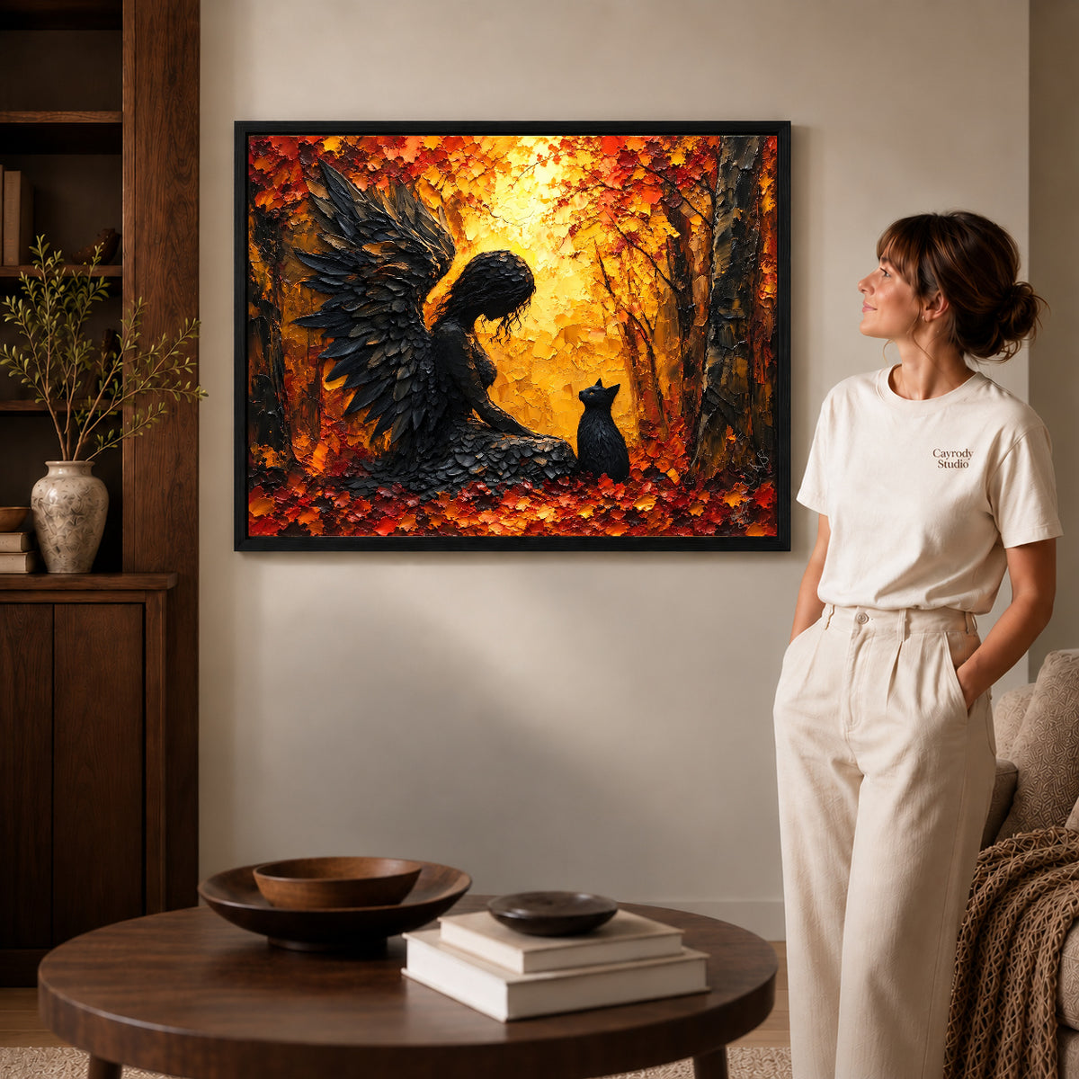 Feathered Guardian Cat canvas art in a black frame above books in a welcoming living room.