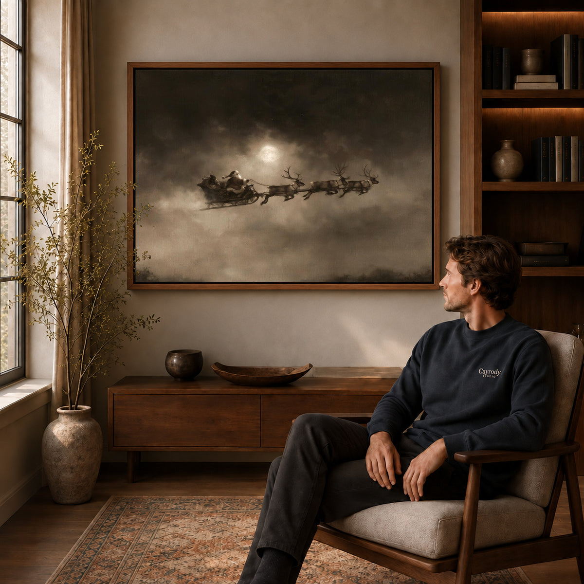 Moonlit Sleigh canvas art above a wooden console beside a seated man in a warm room.