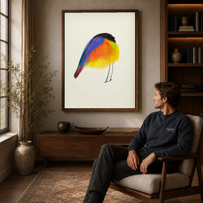 Colorful Bird canvas art above a wooden console beside a seated man in a warm room.